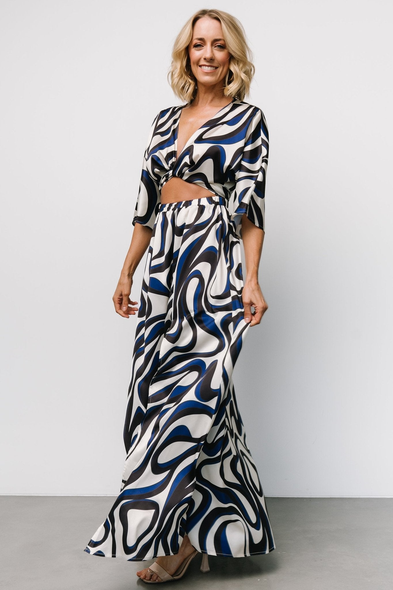 Model wearing the ivory multi-print Stella Maxi Dress; shows length, left leg slit and relaxed resort-ready silhouette in motion.