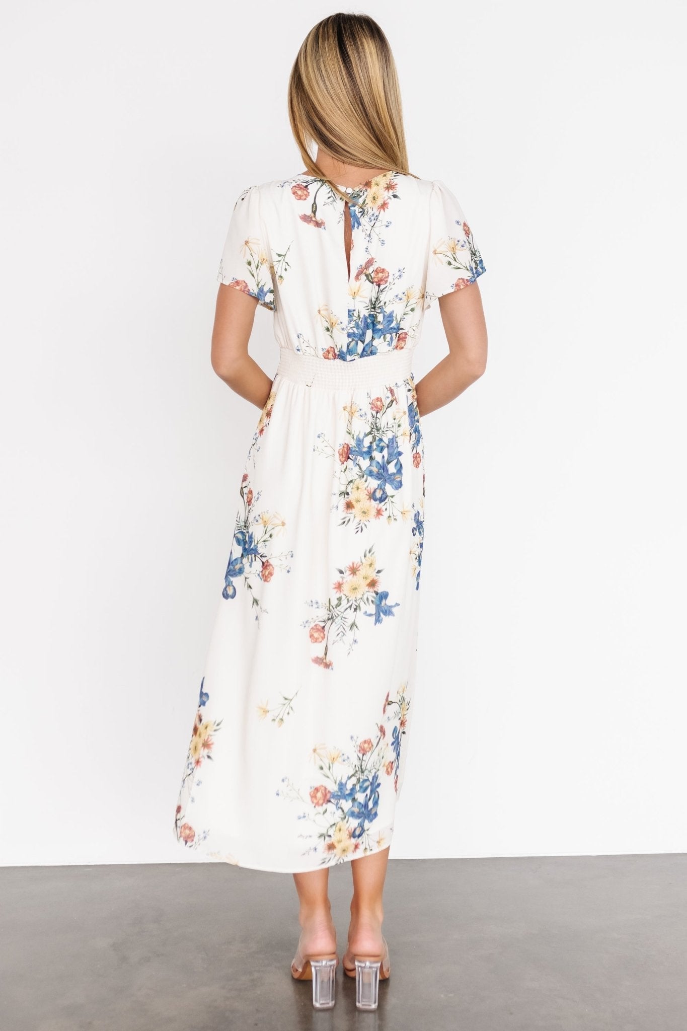 Side profile of cream floral Kirsten Midi Dress on model, emphasizing the drape of the chiffon skirt and natural waist shaping.