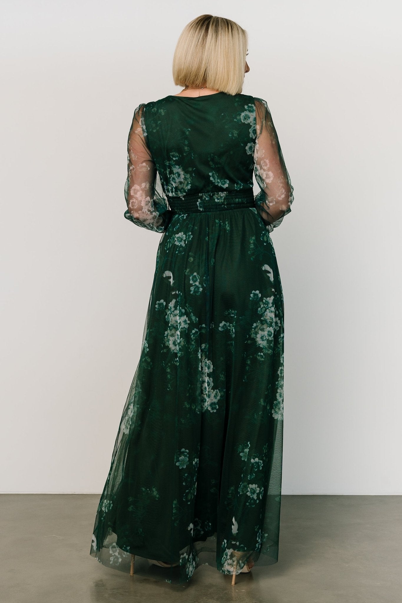 Side view of Layla Tulle Maxi Dress in Dark Green Multi showing silhouette, raw hem length, and how the skirt moves with each step on model.
