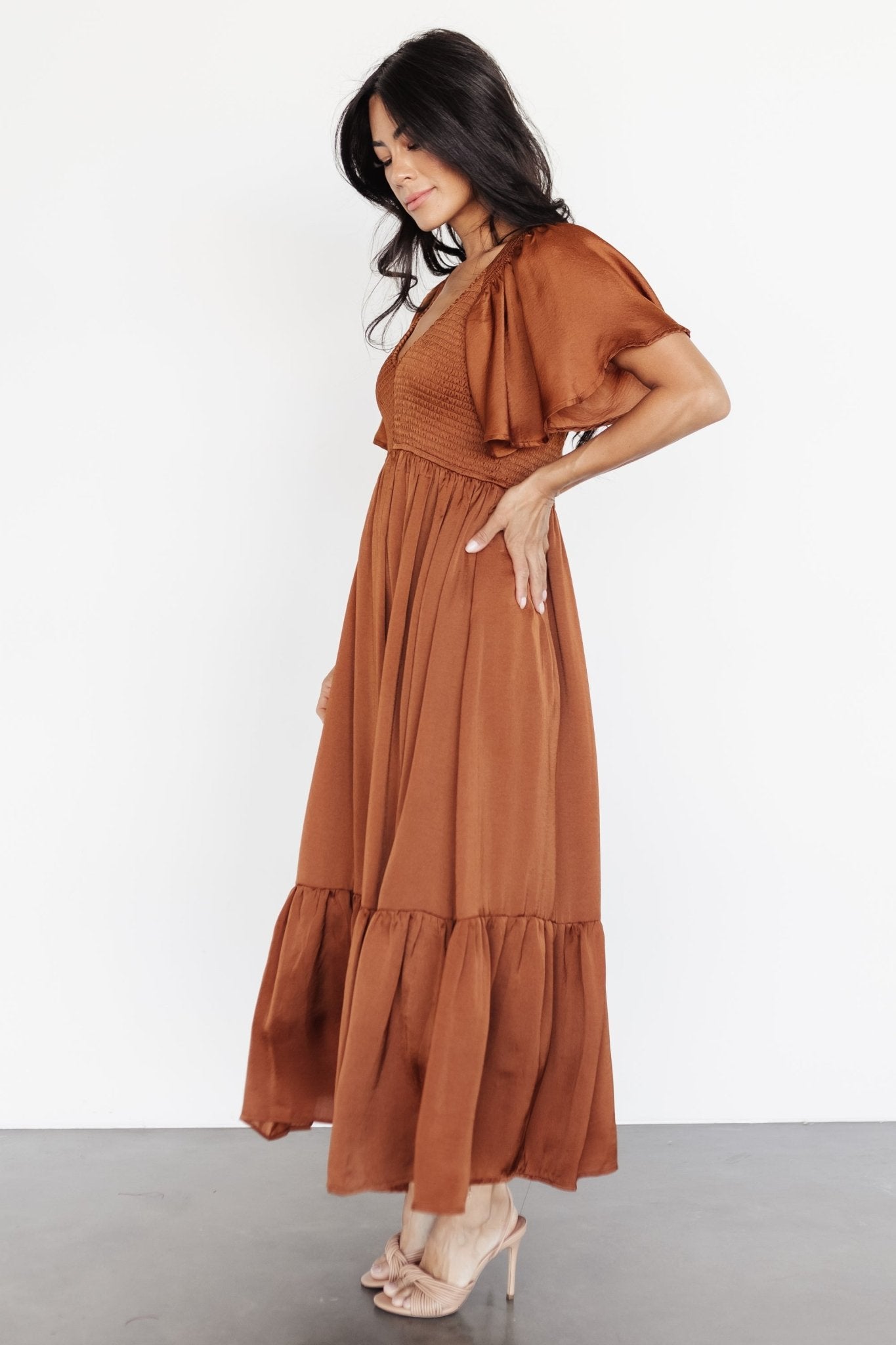 Styled outfit shot of dark copper midi dress paired for occasion wear, highlighting overall silhouette and length.