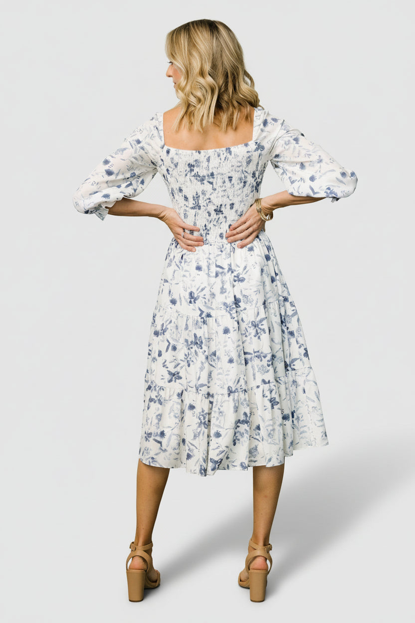 Detail shot of the 3/4 ruffle sleeve and elastic cuff on the Marta Smocked Midi Dress in white and blue floral.