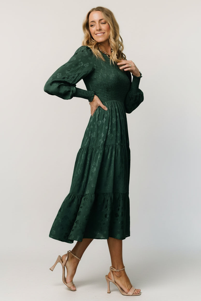 Close-up of smocked bodice and subtle shiny floral texture on the dark green Stockholm Smocked Dress, highlighting elasticized detailing.