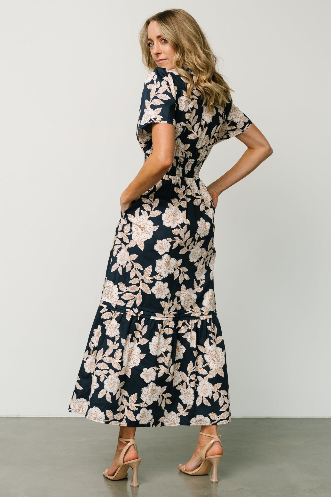 Close-up of bodice and smocked waistband on the Vera Maxi Dress in navy floral showing fabric texture and notched V-neck detail.