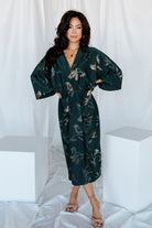 Three-quarter view of the jade floral shimmer Shaneen midi dress highlighting elbow-length dolman sleeves and subtle metallic sheen.