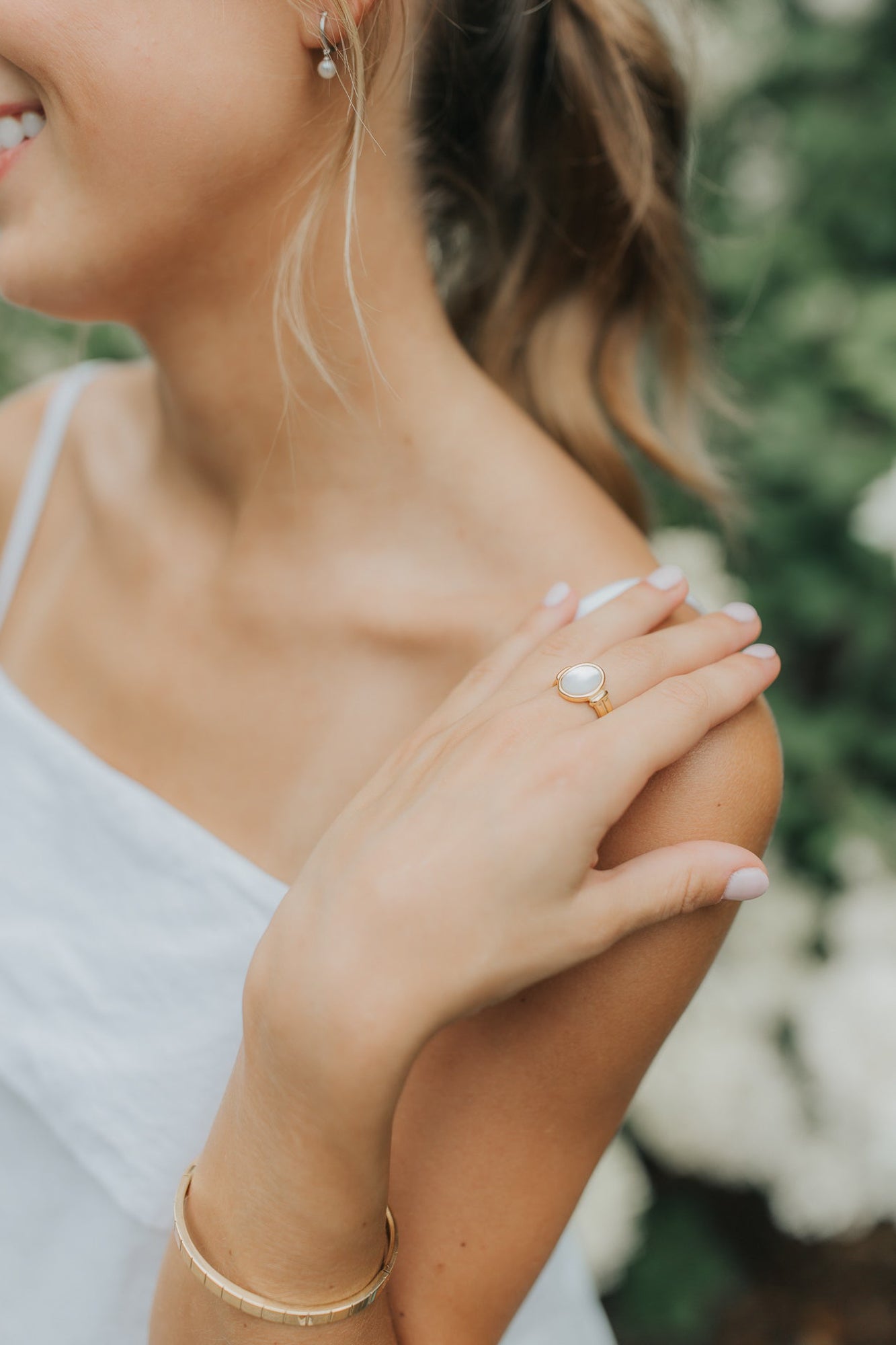 Model wearing the Broadwater ring on the hand, showing scale and fit with the oval mother-of-pearl catching natural light against skin tone.
