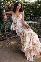 Model walking in the Angelica Tiered Maxi Dress, showing movement of tiers and a flattering, flowy silhouette in a buttercream floral pattern.