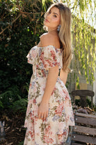 Side view of floral chiffon maxi highlighting elastic neckline that can be worn on or off the shoulder and flowing tiered skirt movement.