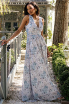 Front view of model wearing Imogen Maxi Dress in light blue floral chiffon, deep V-neck, smocked waist, full flowing maxi skirt, sleeveless.
