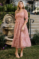 Front view of a model wearing the Fabian Jacquard Midi Dress in Mauve + Gold, showing square neckline, smocked bodice, and tiered midi skirt movement.