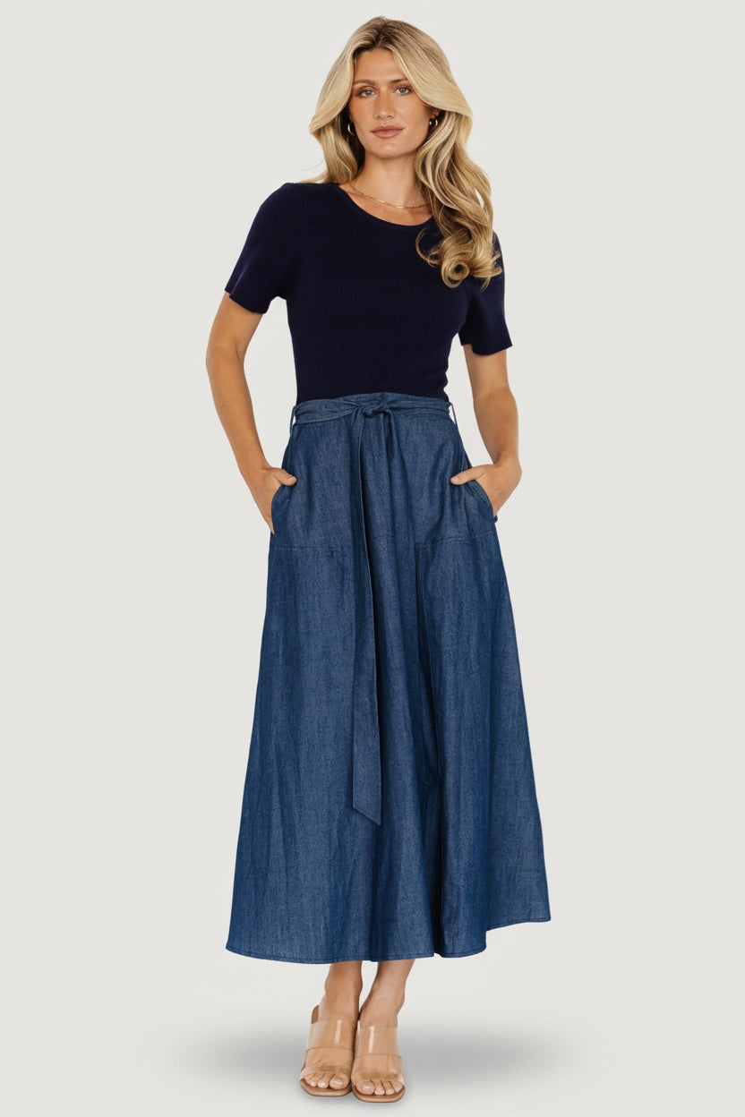 Full-length front view of chambray and navy Olina midi dress on model, showing ribbed bodice, round neckline, and denim skirt.