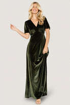 Back view of the olive velvet dress on a plain background, showing keyhole closure and the graceful fall of the gown-length skirt.