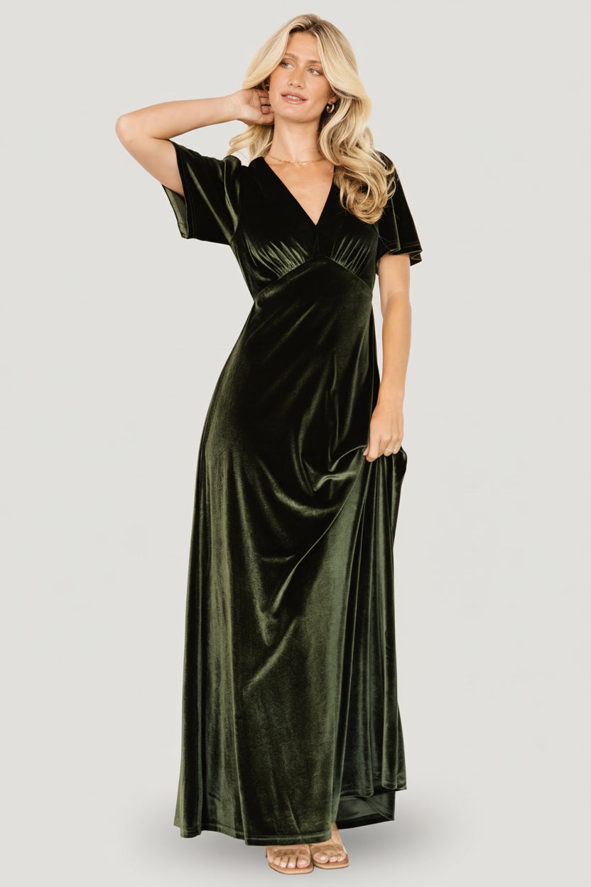 Model walking in olive velvet maxi on a studio floor, demonstrating skirt movement and the elegant, floor-skimming silhouette.