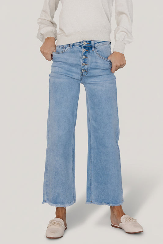 Front view of Brody light-wash high-rise wide-leg cropped jeans on model, showing button-front closure, five-pocket styling, and raw hem detail.