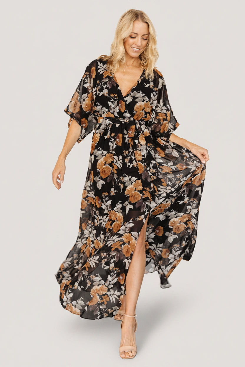 Three-quarter view showing crossover surplice neckline and loose kimono sleeves on the Kia Kimono Maxi Dress in Black + Copper Floral.