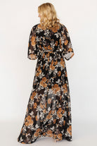 Back and hem view showing full maxi length, soft drape, and floral pattern on the Kia Kimono Maxi Dress in black and copper.