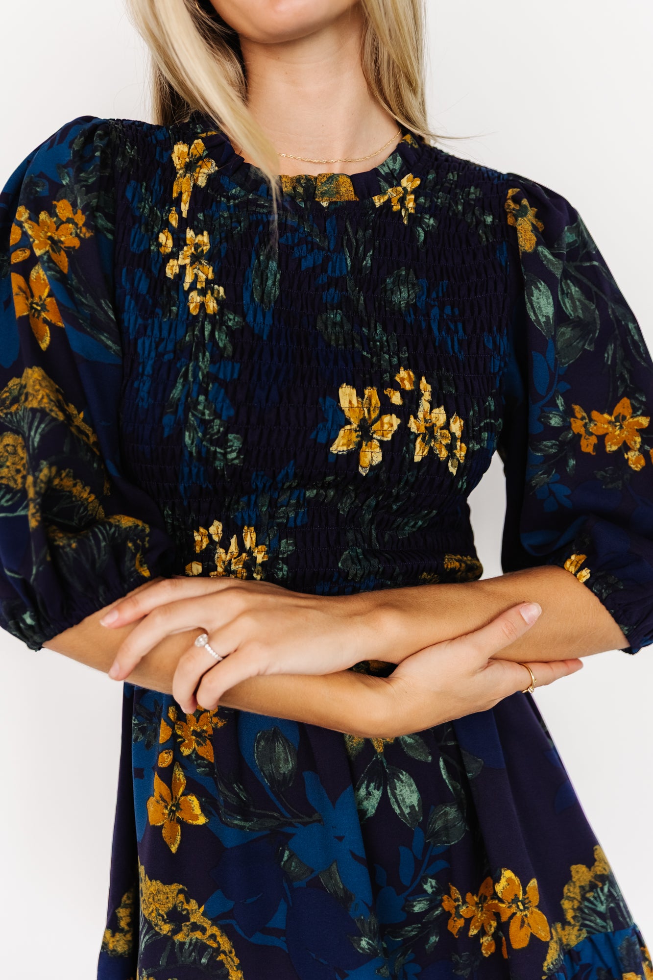 Back view of the Lena Tiered Midi Dress showing the keyhole and button closure at the high ruffle neckline and the flowing tiered skirt.