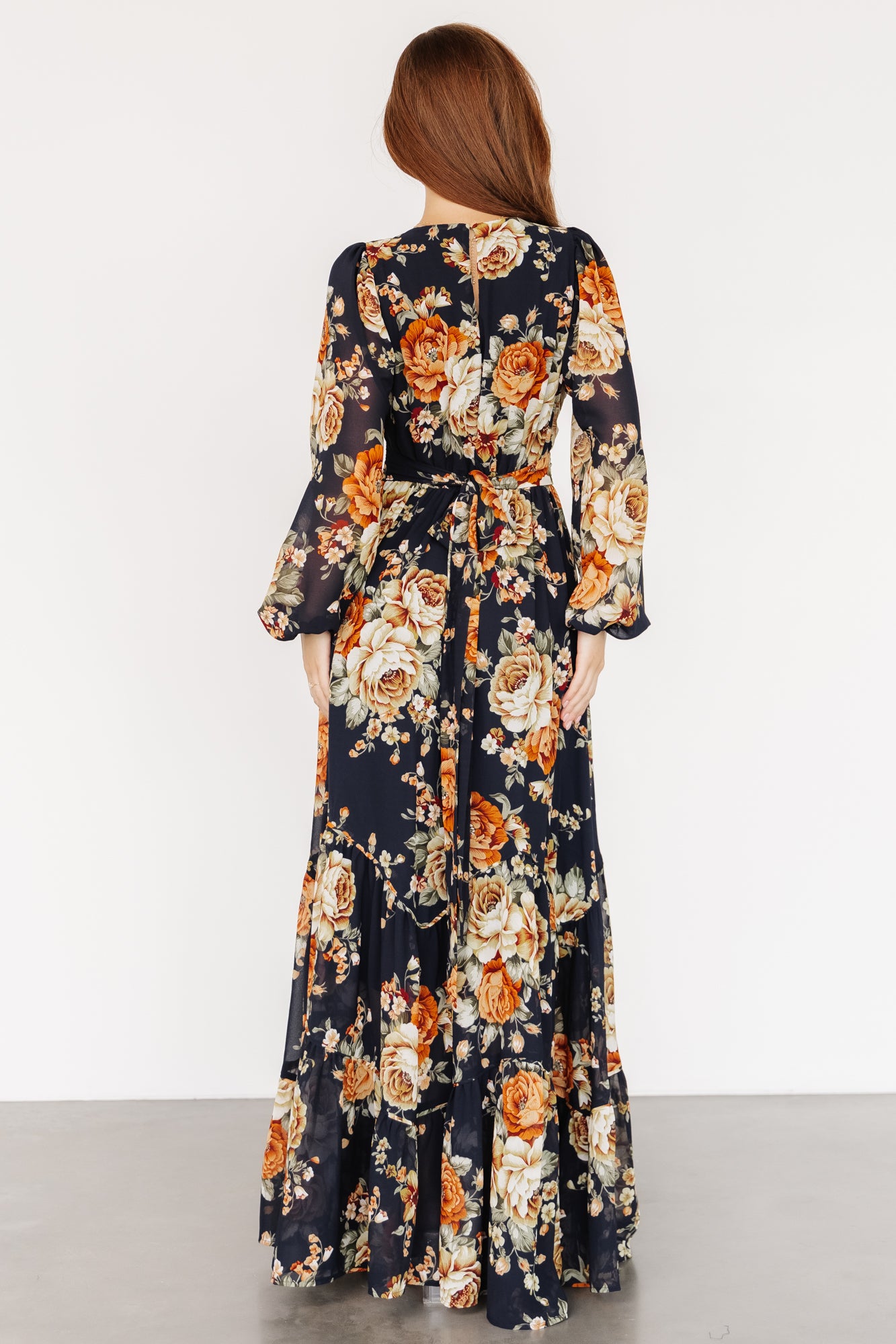 Back view of the maxi dress showing the keyhole closure, button at the neck, and soft drape of the tiered chiffon skirt.