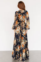Back view of the maxi dress showing the keyhole closure, button at the neck, and soft drape of the tiered chiffon skirt.