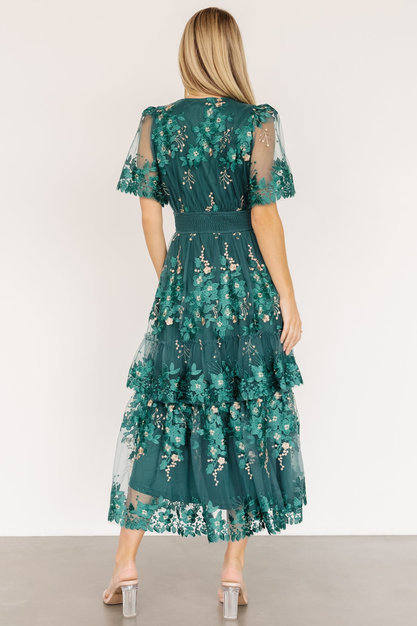 Side view of Lotte midi dress showing scalloped sheer short sleeve, smocked waistband and gentle flare of the tiered skirt.