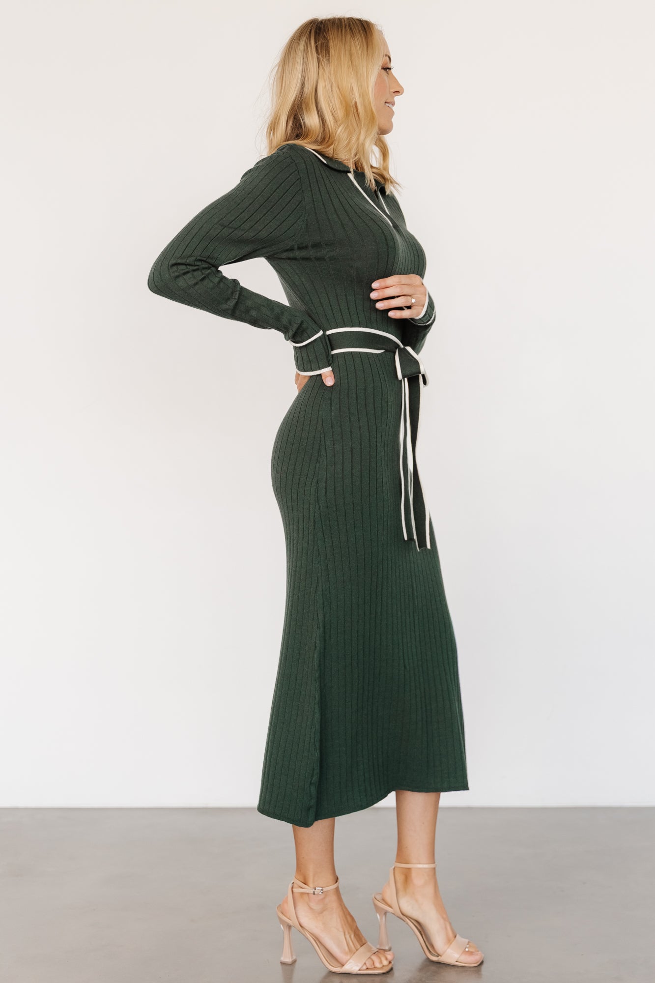 Close-up of the removable waist sash tied at the model's waist, illustrating fabric drape, texture, and styling options for shaping the silhouette.