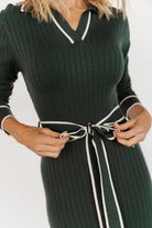 Three-quarter angle of the Lark sweater dress in green on model, highlighting long sleeves, ribbed texture, and the close-to-body midi silhouette.