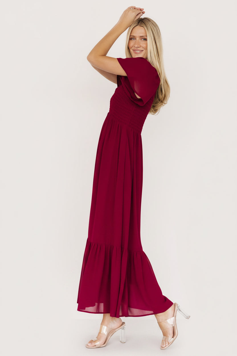 Close-up detail of center-seamed smocked bodice and V-neckline with delicate smocked shoulder on mulberry fabric.