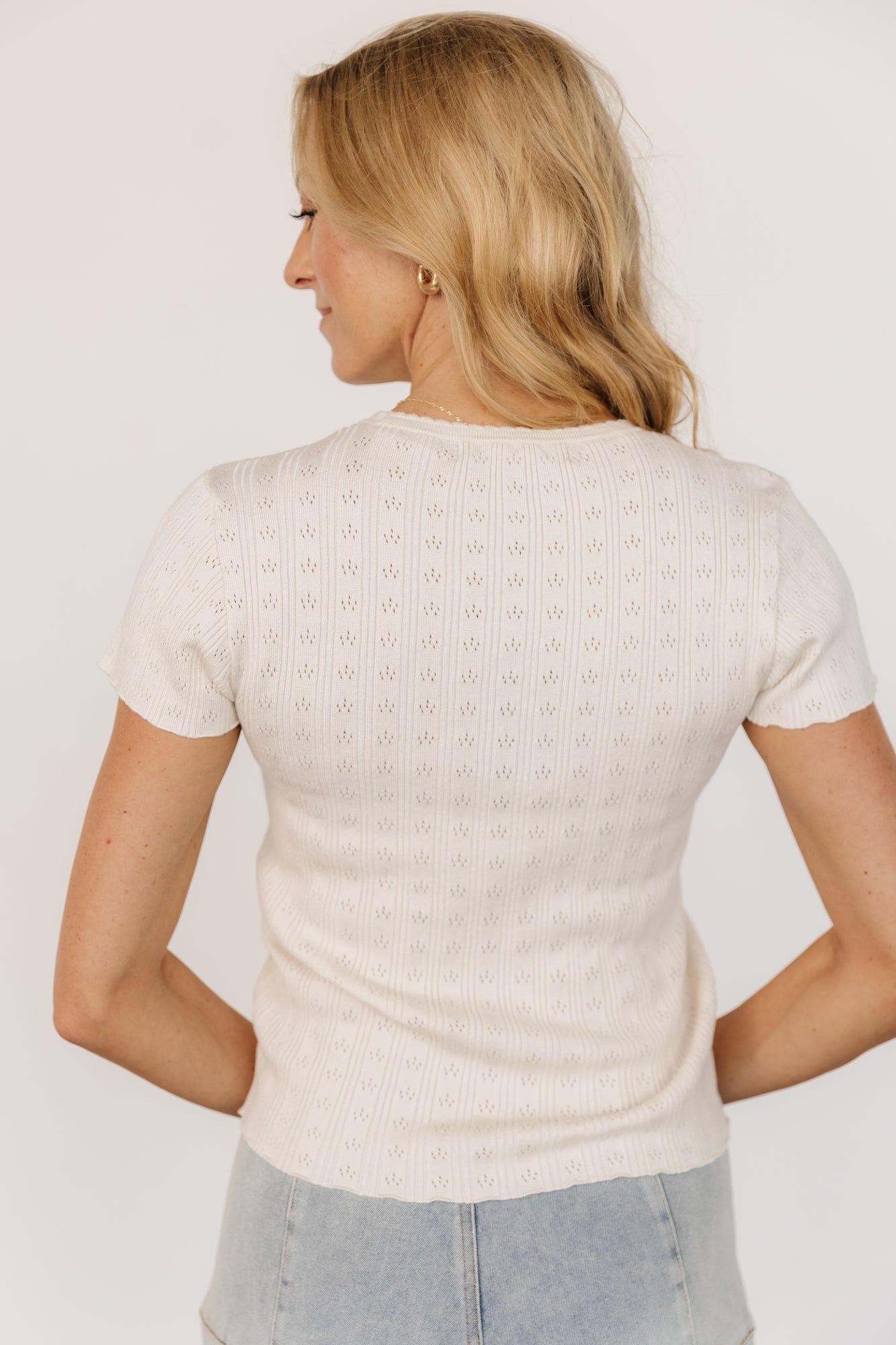 Studio flatlay of the Penny Pointelle Top in ivory, emphasizing scalloped trim at neckline, cuffs, and hem.