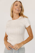 Back view of the Penny Pointelle Top in ivory on model, showing fit, ribbed back panel, and short sleeve length.
