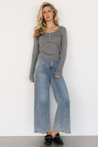 Side view of model wearing the Leo Ribbed Henley Top in gray, showing sleeve length, slim fit, and ribbed hem.