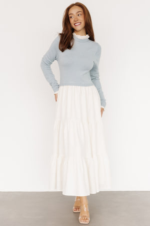 Front view of Sophie Sweater Dress in light blue and ivory showing ruffled neckline, long sleeves, and tiered maxi skirt with pockets, on model.