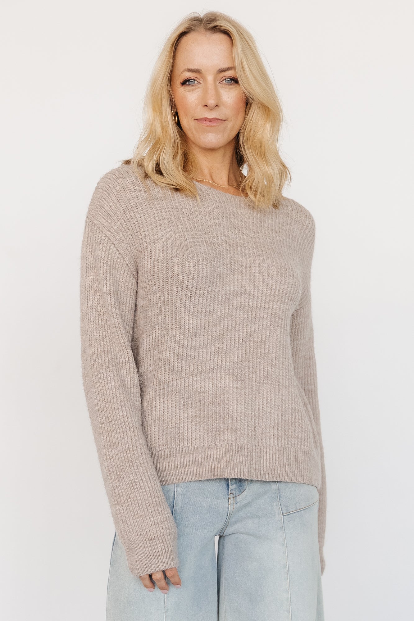 Model wearing Viola Tie Back Sweater in Natural, front view showing boat neckline, relaxed drop shoulders, and soft sweater knit texture.