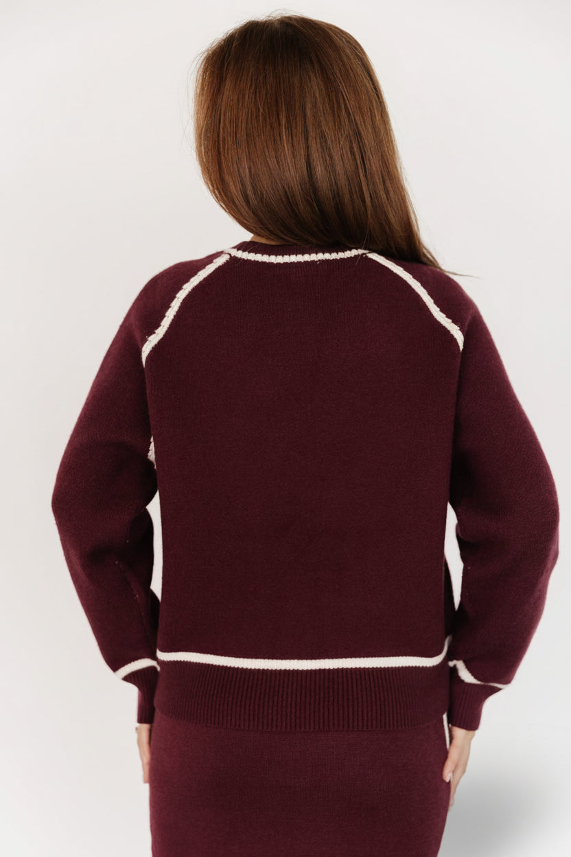 Close-up of knit texture and cream piping on the Ava sweater, showing soft viscose-blend fabric and fine woven stitch detail.