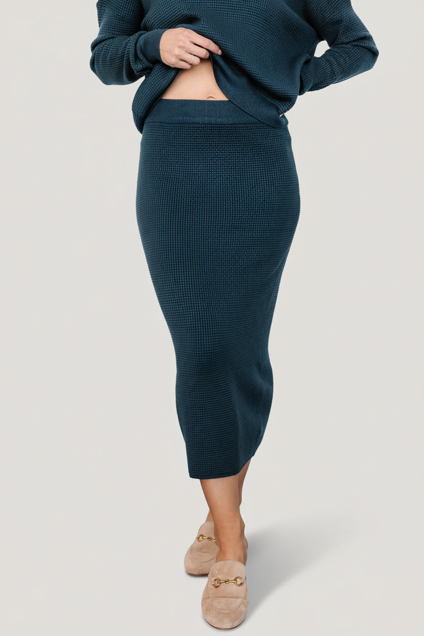 Front view of Carey Waffle Midi Skirt in midnight blue on a model, showing ribbed waistband and fitted silhouette across the hips.