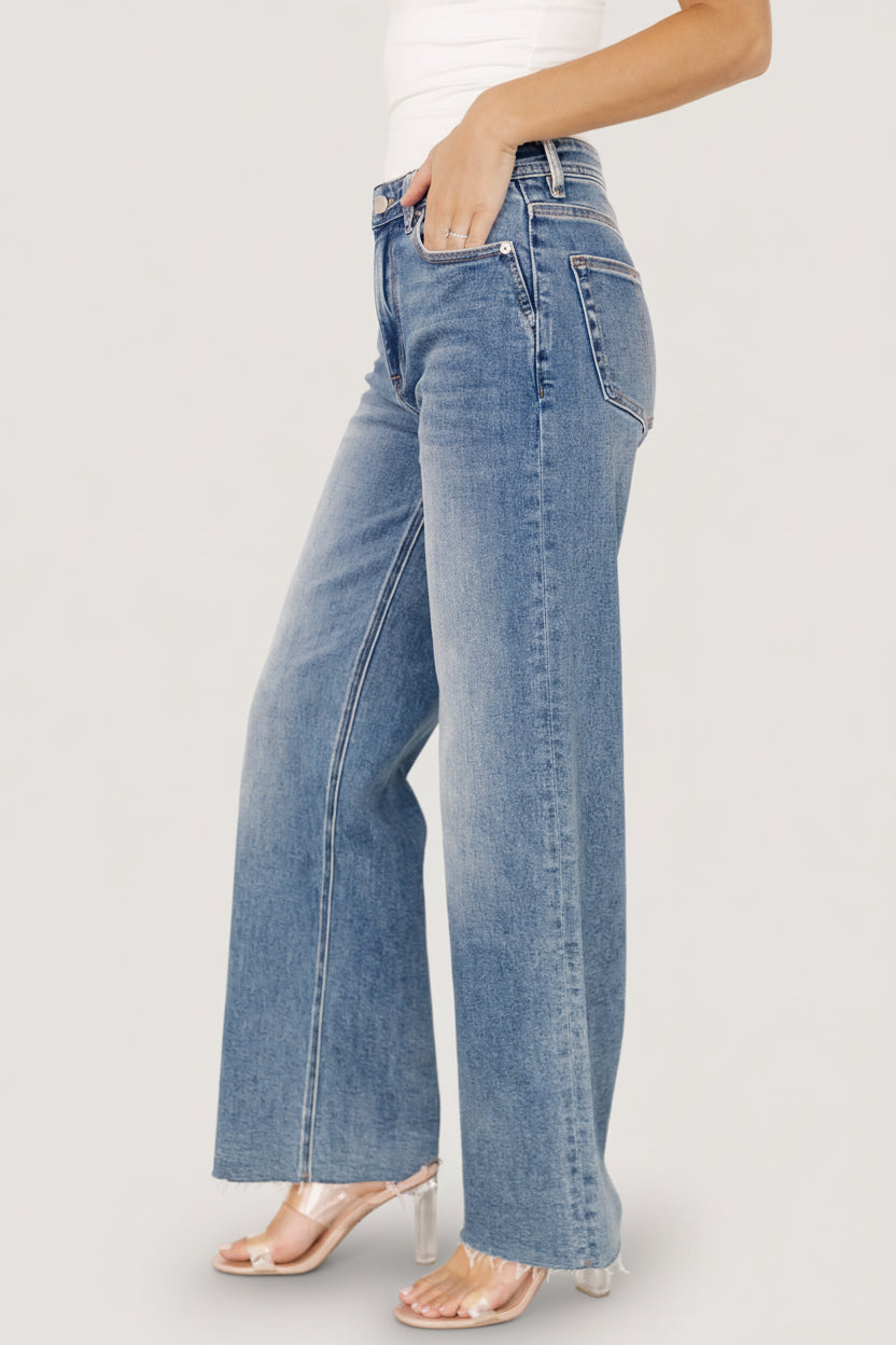Close-up of medium wash denim showing texture, subtle fading, and the fabric's soft stretch for comfortable movement.