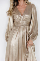 Full-length shot of the Aisha shimmer midi dress in champagne, displaying gathered skirt movement and midi hem hitting below the knee.