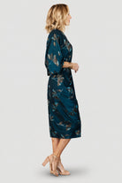 Full-length shot of the Shaneen ruched midi dress in jade floral shimmer, showing silhouette, midi hem and travel-friendly knit.