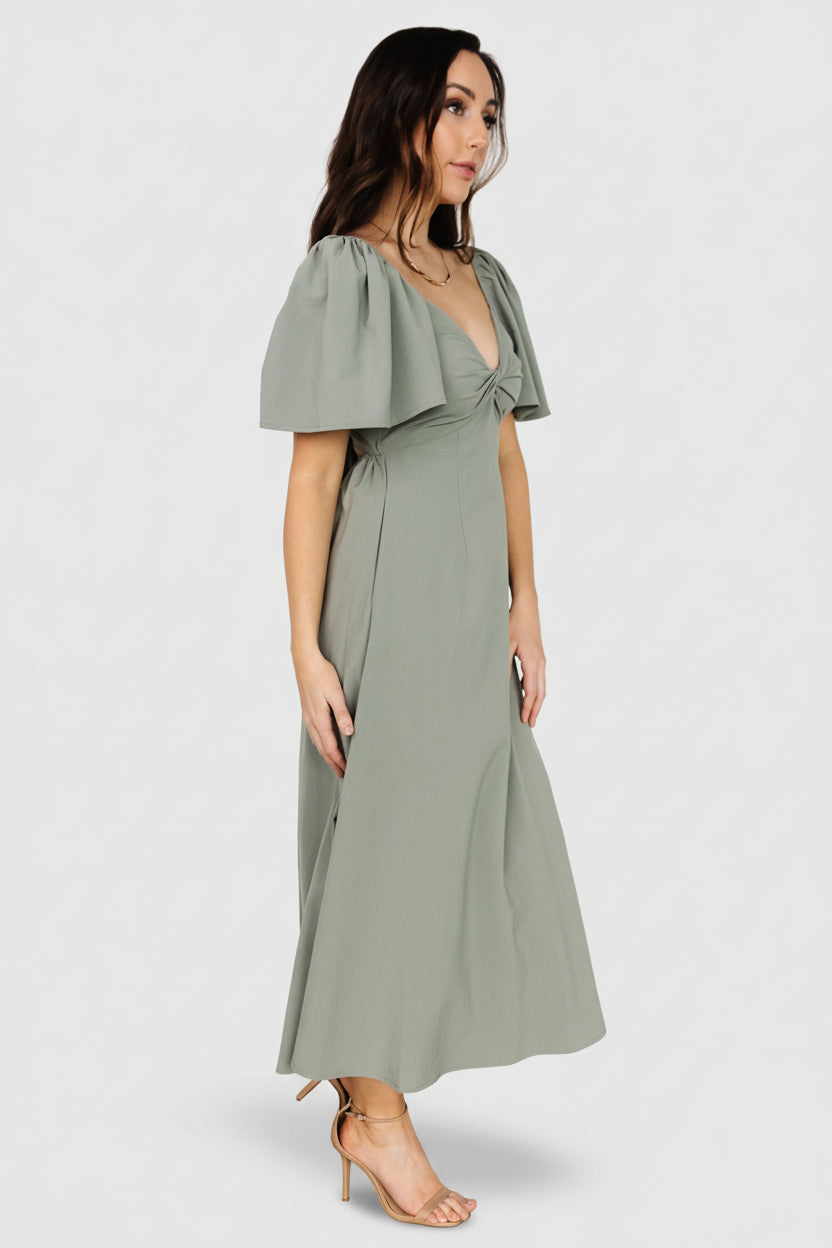 Side profile of dusty green midi highlighting hidden side pocket placement, smooth waistline, and flowing skirt length.