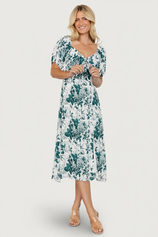 Front view of Cadence Midi Dress in jade floral on model showing sweetheart neckline, short puff sleeves, smocked back, and A-line midi skirt with side slit.