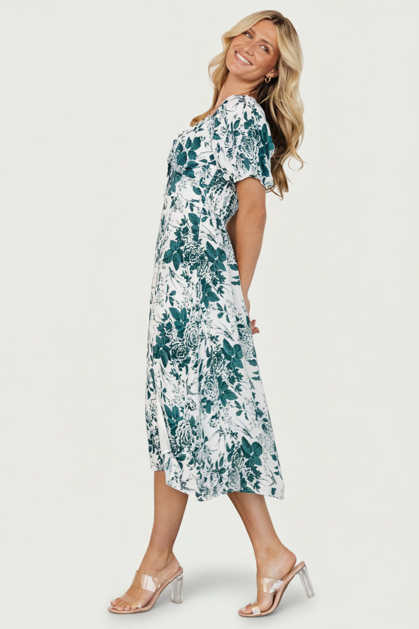 Side view of Cadence Midi Dress in jade floral highlighting the left-leg slit, A-line skirt drape, and delicate botanical print.