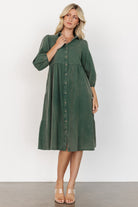 Casual styling shot of the green Sari Babydoll Dress paired with boots, showing length, movement, and easy everyday wearability.