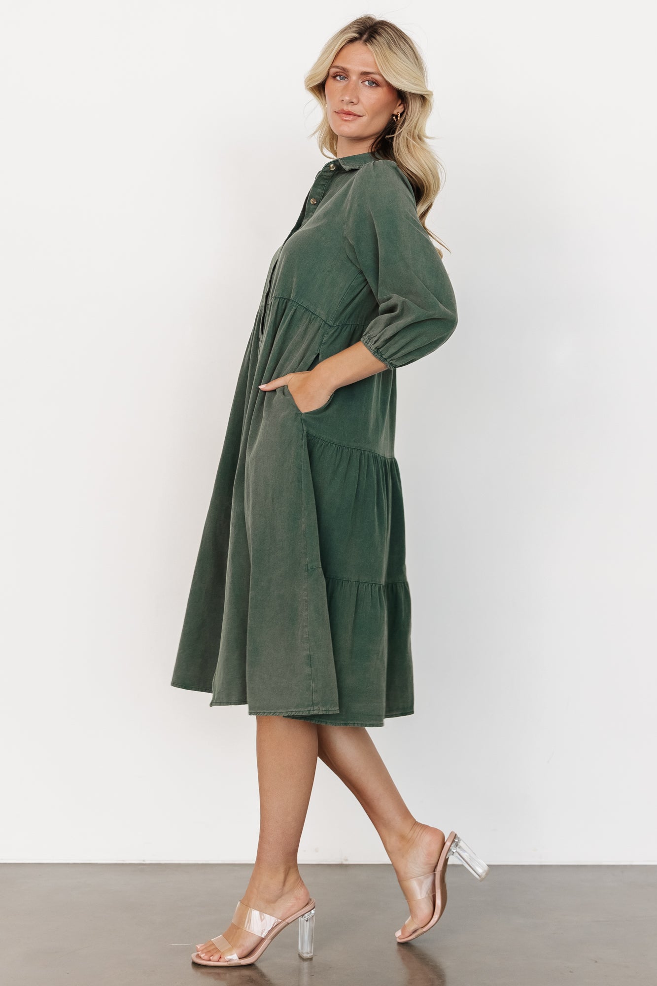 Side view of the Sari Babydoll Dress in green with visible tiered skirt, relaxed fit silhouette, and practical side pocket detail.