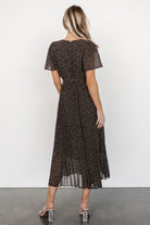 Studio shot of Prim Pleated Midi Dress on mannequin highlighting the lined skirt, sheer short sleeves, and removable waist tie in floral print.