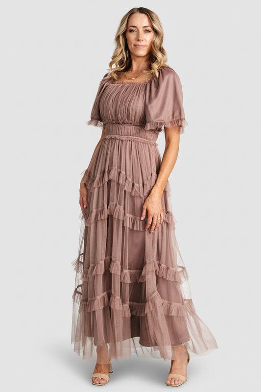 Front model view of Magdalena Tulle Maxi Dress in dusty mink, showing square neckline, short ruffled sleeves, and tiered ruffle skirt.