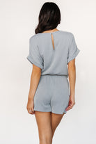 Close-up of the textured vertical fabric ribs on the dusty blue Lely romper, showing material stretch and subtle raised pattern.