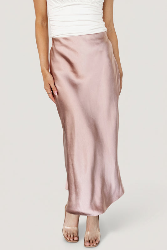 Model wearing blush satin midi skirt, front view showing bias-cut drape and mid-calf length silhouette.