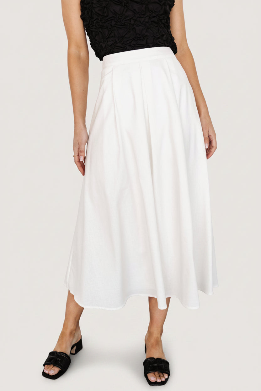 Flat-lay or styled shot of the off-white pleated midi skirt showing overall silhouette, pleat structure, and fabric color.
