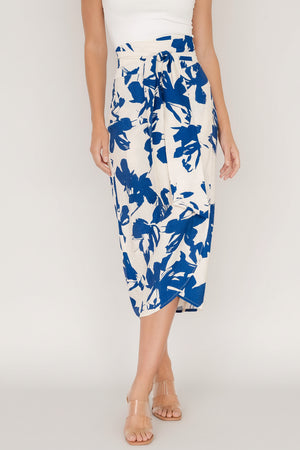 Front view of blue abstract floral wrap midi skirt showing high waist, adjustable tie, and tulip hem with lightweight drape across model.