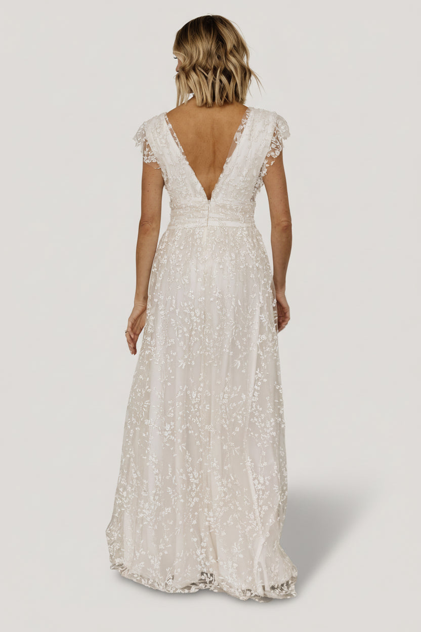 Styled full-length image of Arlene Shimmer Maxi Gown in ivory on model, showing drape, movement, and overall formal silhouette.