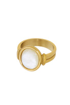 Styled shot of Broadwater ring on a neutral surface highlighting the polished gold band and subtle iridescence of the oval mother-of-pearl stone.