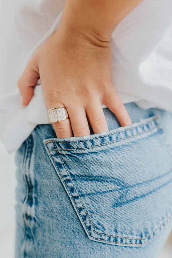 Studio close-up of the Alys ring on a white background showing the wide gold-tone band and vertical mother-of-pearl panels, smooth interior visible.